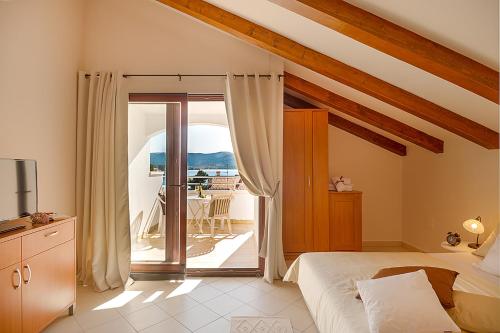 a bedroom with a bed and a sliding glass door at Villa Croatica Apartments in Zaboric