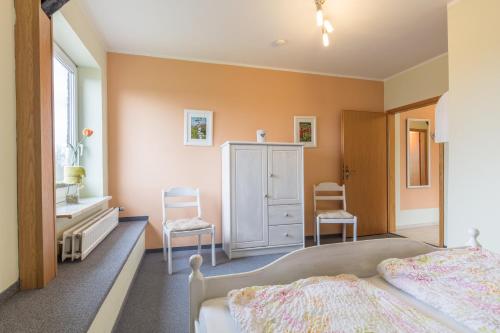 a bedroom with two beds and two chairs at Bauernhof Marquardt in Fehmarn