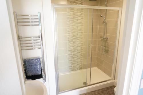 a glass shower in a bathroom with a toilet at shoreside inn in Shanklin