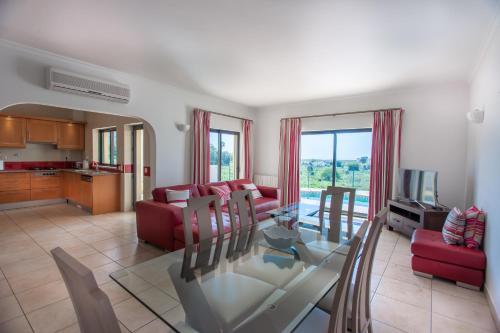 a living room with a glass table and red furniture at Villa Vista Anders Mar in Lagos