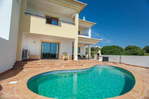 a villa with a swimming pool in front of a house at Villa Vista Anders Mar in Lagos