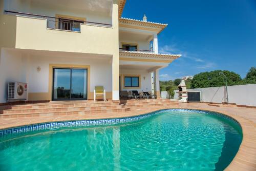 a villa with a swimming pool in front of a house at Villa Vista Anders Mar in Lagos