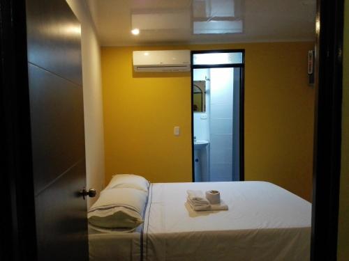 a bedroom with a bed with two towels and a mirror at Hotel Español Neiva in Neiva