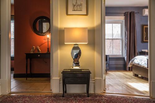a room with a bed and a lamp on a table at Auberge aux Deux Lions in Quebec City