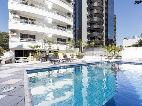 a swimming pool in front of a building at Bela Vista Hotel & Flat in Porto Alegre