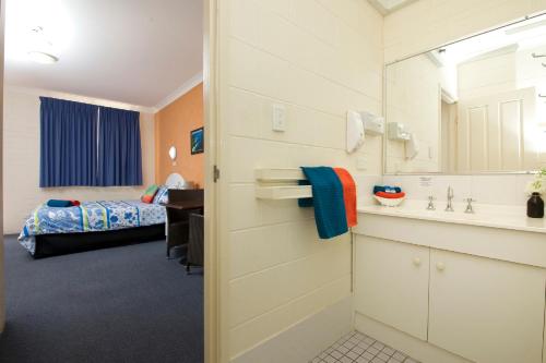 タンカリーにあるTuncurry Beach Motelのベッドルーム1室(ベッド1台、バスルーム付)