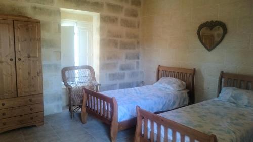 1 dormitorio con 2 camas, armario y sillas en Citadel View Farmhouse, en Victoria