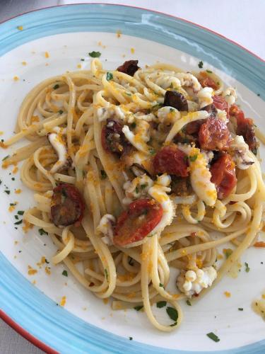 a plate of pasta with shrimp and cheese at La Banchina Holiday Rooms in Trani