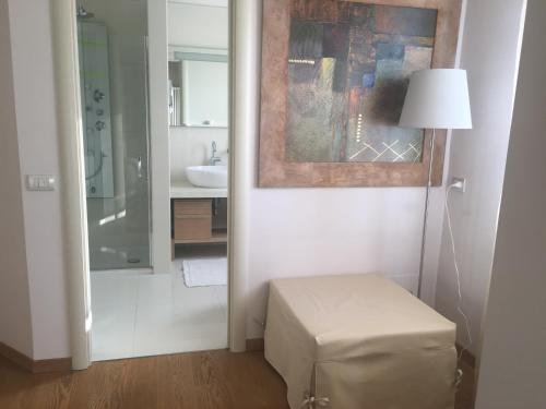a white bathroom with a stool and a lamp at B&B Villa Brema in Sirmione
