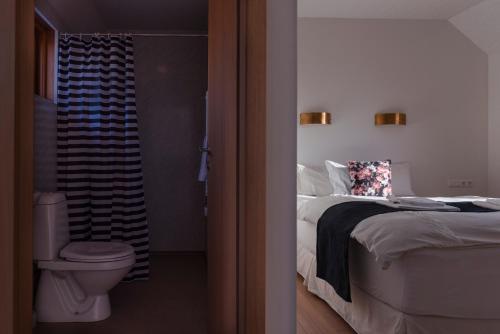 a bedroom with a bed and a bathroom with a toilet at Guesthouse Brekka in Brekka