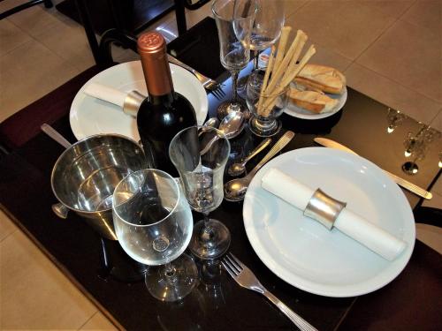 a table with plates and glasses and a bottle of wine at Kitek Hotel Boutique in Mendoza