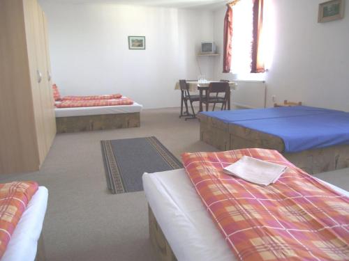 a room with two beds and a table in it at Penzión Slávia in Poprad