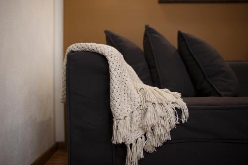 a blanket on the side of a black couch at Maja Hotel Boutique in Morelia