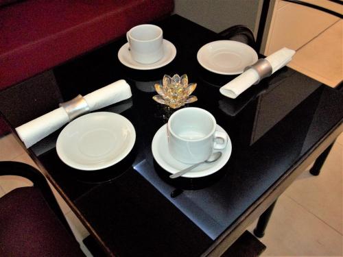 a table with two cups and saucers on it at Kitek Hotel Boutique in Mendoza