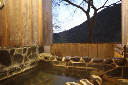 a swimming pool with a window and a wooden fence at Amagiso in Kawazu