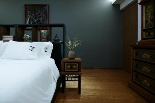 a bedroom with a bed and a table with a vase on it at Maja Hotel Boutique in Morelia