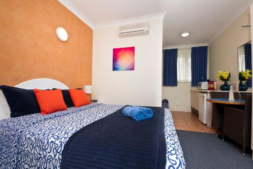 a hotel room with a bed and a desk at Tuncurry Beach Motel in Tuncurry