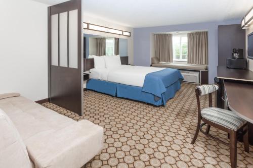 a hotel room with a bed and a couch at Microtel Inn and Suites Elkhart in Elkhart