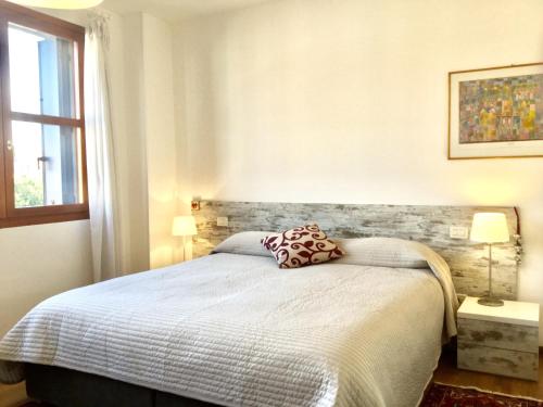 a bedroom with a bed and two lamps and a window at Giudecca View in Venice