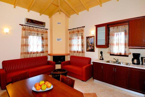 a living room with two red chairs and a table at Mousses Houses in Petra