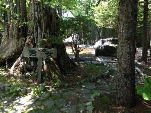 a sign in a forest with trees and rocks at Hotel Parkway in Teshikaga