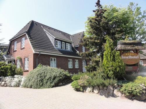 a brick house with a sign in front of it at Inselhotel Arfsten in Wyk auf Föhr