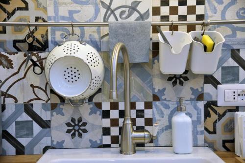 un bagno con lavandino, colino e specchio di A Due Passi B&B a Castellammare di Stabia