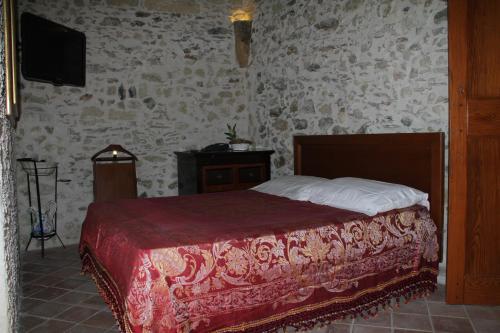a bedroom with a bed and a tv in a room at Residenza d'Epoca Borgodifiume in Fiumefreddo Bruzio