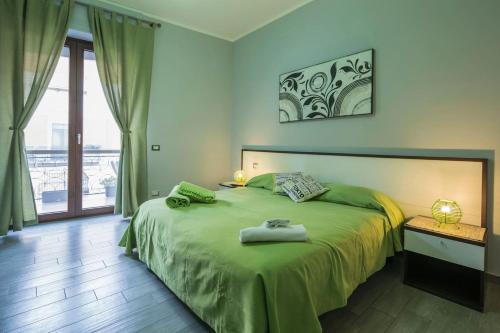 een slaapkamer met een bed met een groene sprei bij B&B Eco in Pompei