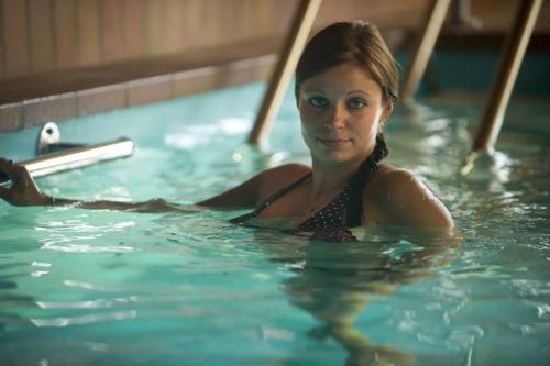 Eine Frau schwimmt im Pool in der Unterkunft Dorf gut Hotel zur Warte in Witzenhausen