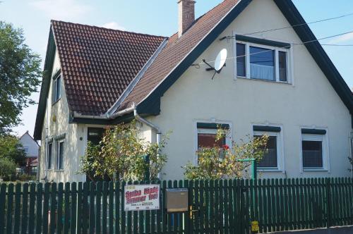 霍爾托巴吉的住宿－Privatzimmer Csikos，白色的房子,有黑色的屋顶和栅栏