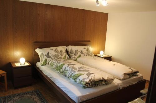 ザース・グルントにあるChalet Alpentraumのベッド1台(枕2つ、ランプ2つ付)