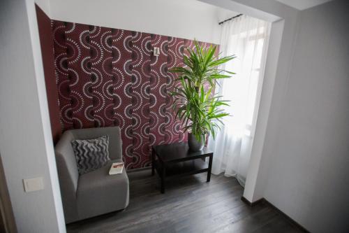 a room with a chair and a plant on a wall at Park Apartments in Valmiera