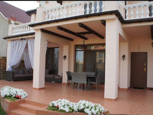 a house with a patio and a dining area at Bonita in Zatoka