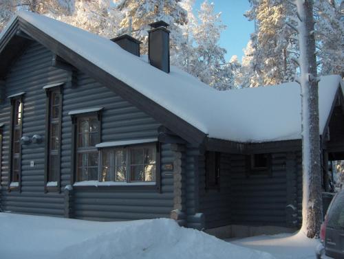 ルカにあるRukavalo Cottageの屋根に雪が積もった丸太キャビン