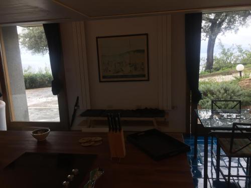 a dining room with a table and two large windows at Villa Li Schisani in Sorrento