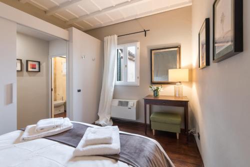 a bedroom with a bed and a desk and a window at Charming Attic Niche in Florence