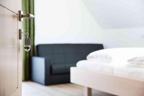 a bedroom with a bed and a black couch at Weingut-Gästezimmer UHL in Ratsch an der Weinstraße