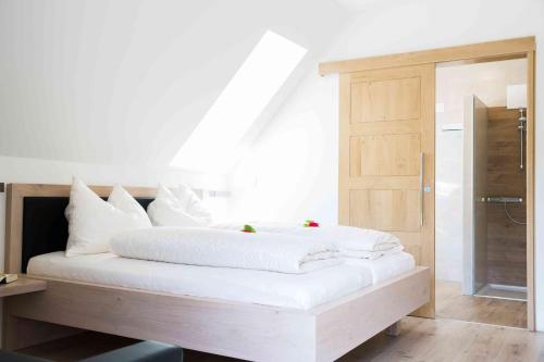 1 cama blanca con almohadas blancas en una habitación en Weingut-Gästezimmer UHL, en Ratsch an der Weinstraße