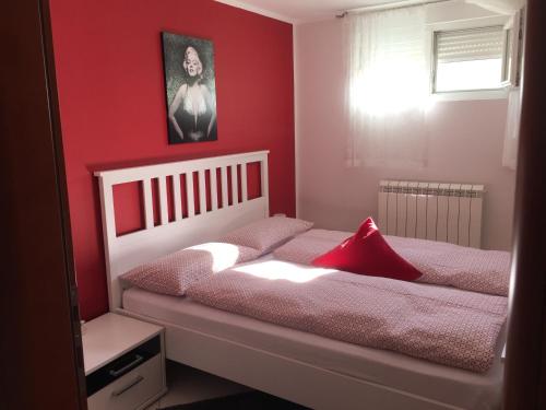 a bedroom with two beds with red walls at Apartments Villa Lili in Umag