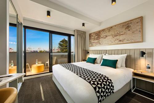 a hotel room with a bed and a large window at Quest Fremantle in Fremantle