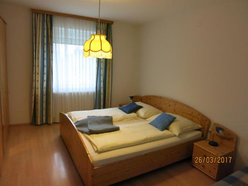 Bett in einem Zimmer mit einem großen Fenster in der Unterkunft Ferienwohnungen Kremsbrucker in Klagenfurt am Wörthersee