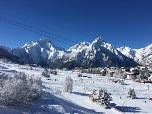 a ski slope with snow covered mountains in the background at Le grenier des rêves in Les Deux Alpes