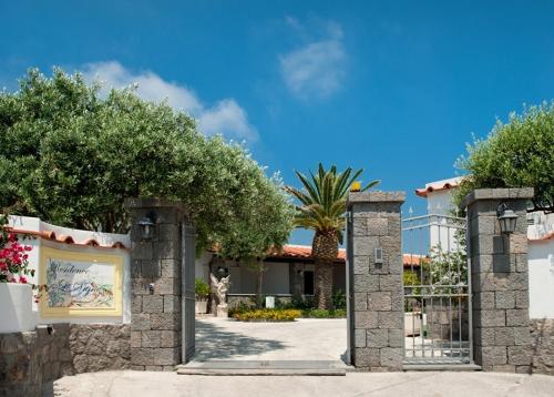 un accès à un bâtiment avec un portail et des arbres dans l'établissement Residence Le Vigne, à Ischia