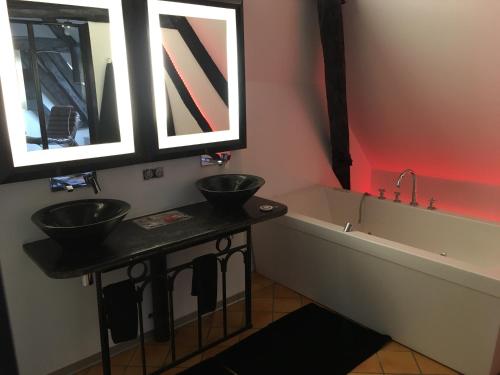 a bathroom with two sinks and a bath tub at Demeure des Vieux Bains in Provins