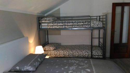 マレスコにあるAppartamento Maury Locazione Turisticaのランプ付きのドミトリールームの二段ベッド2台