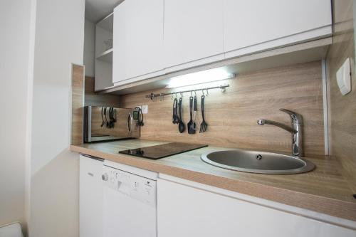 a kitchen with a sink and utensils on the wall at Christiana studios en hyper centre de Valberg aux pieds des pistes in Valberg