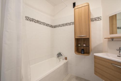a white bathroom with a tub and a sink at Christiana studios en hyper centre de Valberg aux pieds des pistes in Valberg
