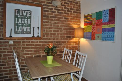 mesa de comedor con sillas y pared de ladrillo en optimist split, en Split