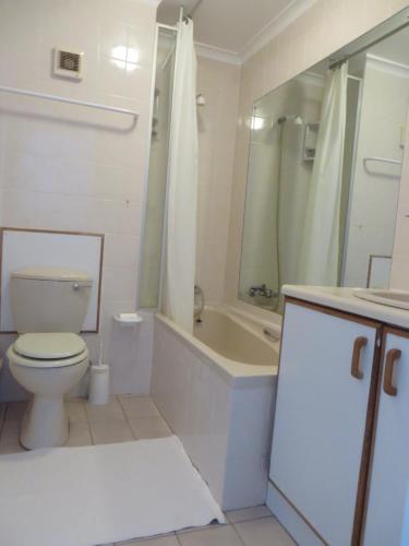 a bathroom with a toilet and a tub and a sink at No. 1 Living Waters in Simonʼs Town